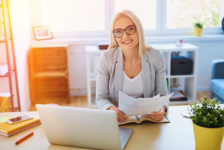 Beautiful businesswoman working with laptop and documents at hom