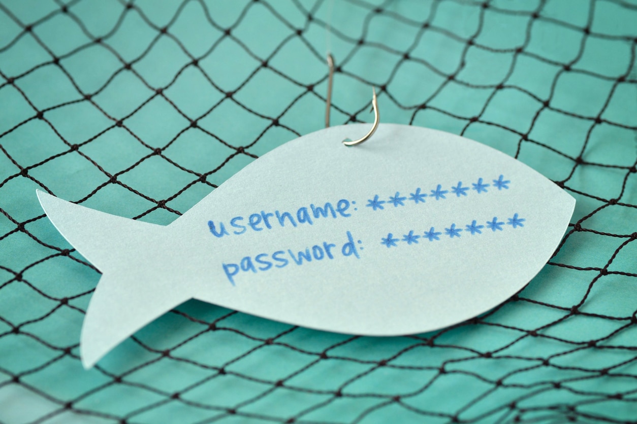 Username and password written on a paper note in the shape of a fish attached to a hook - Phishing and internet security concept